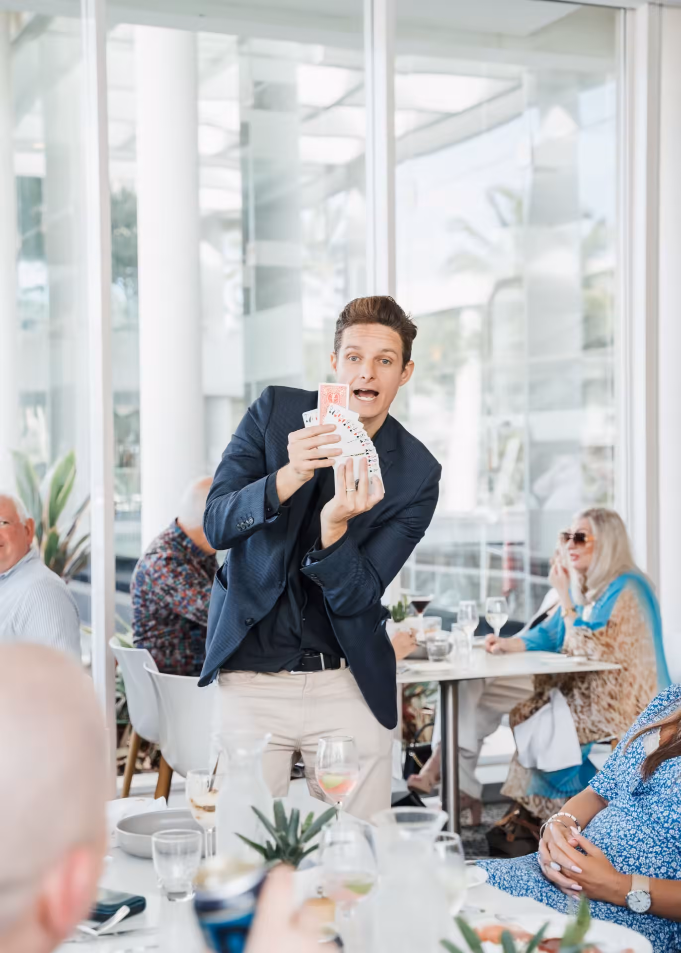 Magician Jason Gray performing card magic in a suit at a function