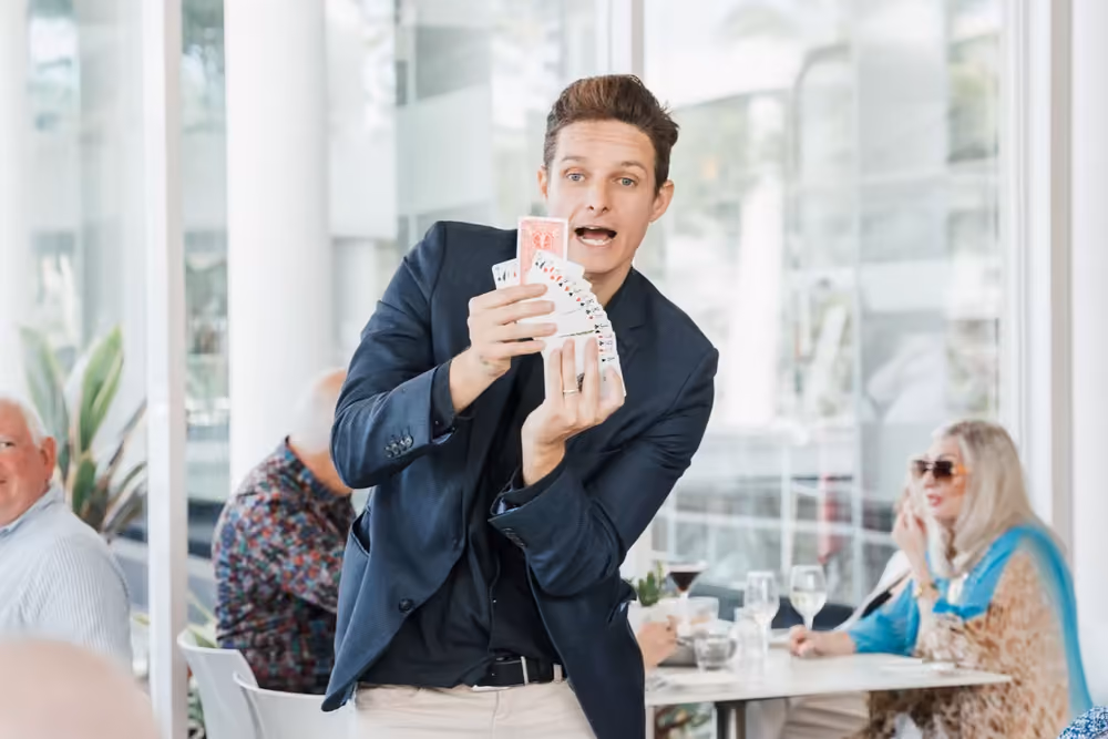 Jason Gray performing close up magic for a group of guests at an event