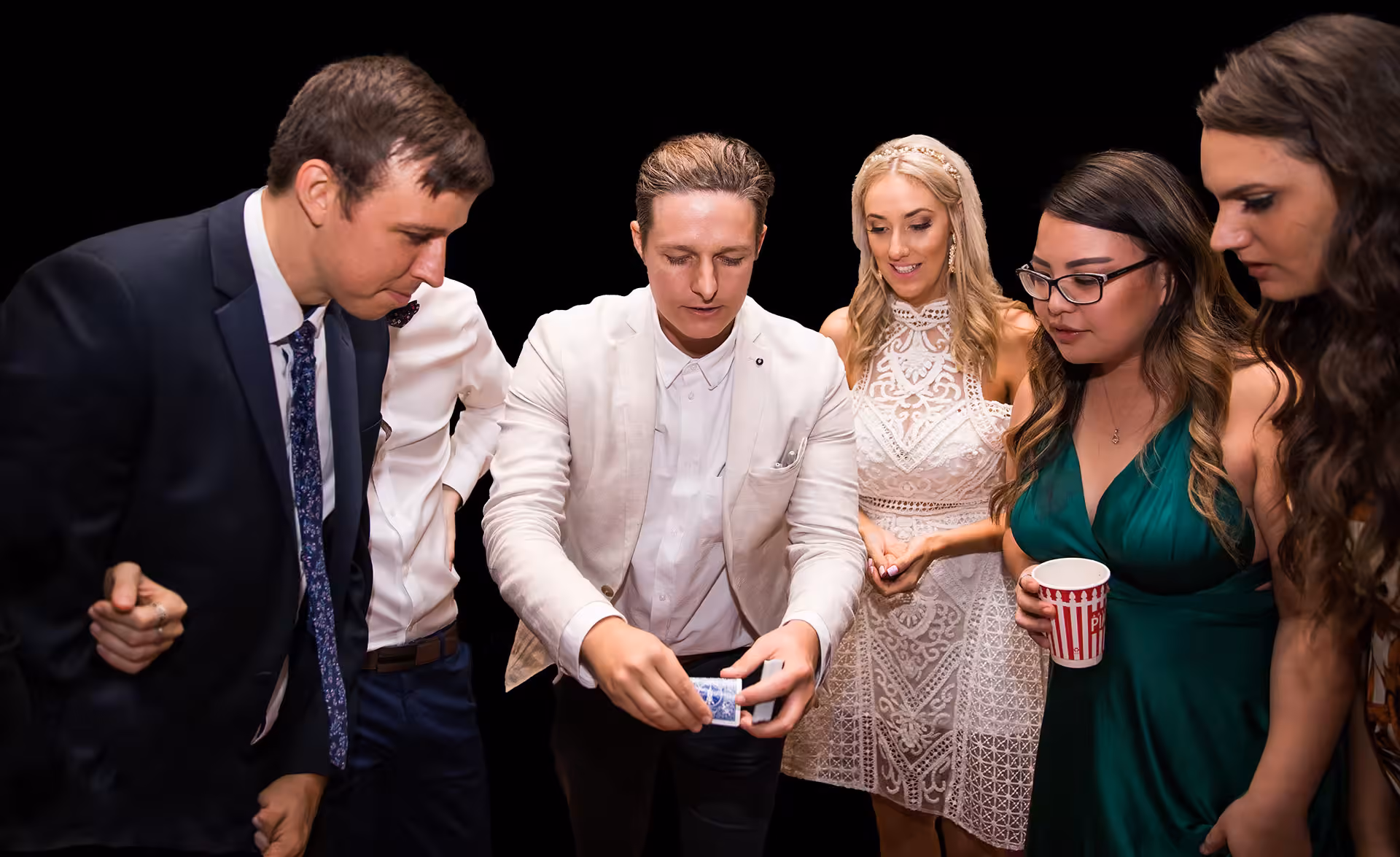 Close up magician Jason Gray performing a card trick at arm’s length for guests at an event