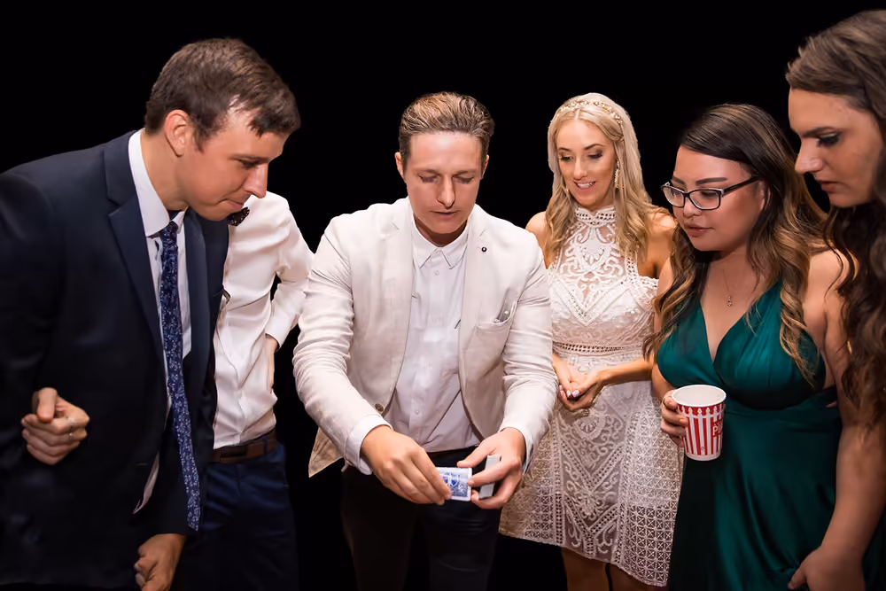 Jason Gray showing a card trick to guests at an event